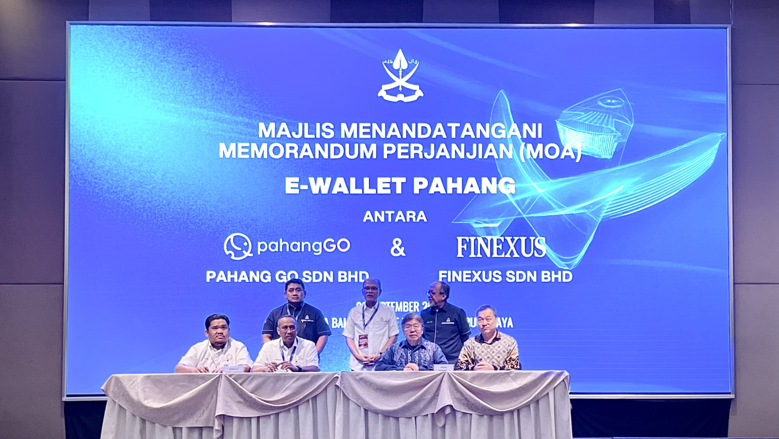 MOA Signing Ceremony signed by YB Dato' Haji Mohammad Fakhruddin bin Mohd Ariff, Chairman, Pahang Go and Pahang State EXCO of Housing, Local Government, Environment, and Green Technology (front row, 2nd from left), witnessed by YAB Dato' Sri Diraja Haji Wan Rosdy Bin Wan Ismail, Pahang Menteri Besar (back row, middle), and Joel Choo, R&D Director, Finexus Group (front row, 2nd from right) representing Finexus Group CEO Clement Loh, witnessed by Yong Sin Yoon, Acquiring Business Director, Finexus Group (front row, most right)